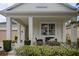 Inviting porch with comfortable wicker seating area enhanced by lush landscaping at 12679 Calderdale Ave, Windermere, FL 34786