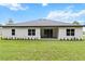 The backyard features a covered patio and lush green lawn, perfect for outdoor entertaining at 136 N James Pl, Groveland, FL 34736