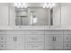 Bathroom featuring double vanity with modern fixtures, large mirror, and tiled floors at 136 N James Pl, Groveland, FL 34736