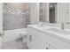 Bathroom featuring a double vanity, tiled shower and floors, and modern fixtures at 136 N James Pl, Groveland, FL 34736