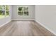 Bright bedroom featuring wood-look flooring, large windows, neutral walls, and white trim at 136 N James Pl, Groveland, FL 34736