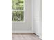 Bedroom featuring a large window with natural light, clean white trim, and wood look flooring at 136 N James Pl, Groveland, FL 34736