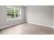 Bright bedroom with a large window and modern wood-look flooring at 136 N James Pl, Groveland, FL 34736
