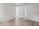 Spacious bedroom with wood-look flooring leading to the open doorways and a peek into the bathroom at 136 N James Pl, Groveland, FL 34736