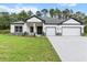 Beautiful single-story home featuring a well-manicured lawn and a three-car garage at 136 N James Pl, Groveland, FL 34736