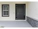 Close-up of the front door showcasing its contemporary design, sidelights, and surrounding architectural details at 136 N James Pl, Groveland, FL 34736