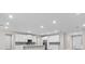 Modern kitchen featuring white cabinetry, gray backsplash, and stainless steel appliances at 136 N James Pl, Groveland, FL 34736