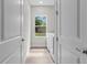 Laundry room featuring a window overlooking greenery, with white doors and neutral paint at 136 N James Pl, Groveland, FL 34736