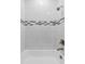 Elegant shower featuring white tile walls with decorative accent tiles and bronze fixtures at 136 N James Pl, Groveland, FL 34736