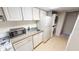 Compact kitchen with full appliances, white cabinetry, and in-unit laundry at 145 Oyster Bay Cir # 200, Altamonte Springs, FL 32701