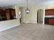 Open concept living room with tile floor, neutral paint, wood cabinets, and modern lighting fixtures at 14508 Cedar Branch Way, Orlando, FL 32824