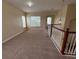 Carpeted loft with a light fixture, windows and wooden railing at 14508 Cedar Branch Way, Orlando, FL 32824