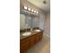 Bathroom with double sinks, granite counters, and separate shower at 16631 Lazy Breeze Loop, Clermont, FL 34714