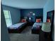 Stylish bedroom featuring two twin beds, sports decor, and a comfortable carpet at 16631 Lazy Breeze Loop, Clermont, FL 34714