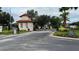 Gated entrance to a residential community with a guard house, gate and manicured landscaping at 16631 Lazy Breeze Loop, Clermont, FL 34714