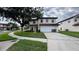 Exterior facade of a two story white house featuring a two car garage, red tile roof, and green lawn at 16631 Lazy Breeze Loop, Clermont, FL 34714