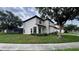 Exterior view of a two-story home featuring stucco walls, red tile roof, and landscaped front yard at 16631 Lazy Breeze Loop, Clermont, FL 34714