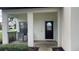 Front porch featuring a decorative glass door, seating, and neutral color palette at 16631 Lazy Breeze Loop, Clermont, FL 34714