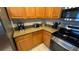 Kitchen with stainless steel appliances, including a range and microwave, with wooden cabinets at 16631 Lazy Breeze Loop, Clermont, FL 34714