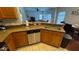 Kitchen featuring a tile floor, wood cabinets, stainless steel appliances, and stone countertops at 16631 Lazy Breeze Loop, Clermont, FL 34714