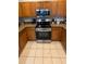 Well-lit kitchen features stainless steel appliances, wooden cabinetry, and tile flooring at 16631 Lazy Breeze Loop, Clermont, FL 34714