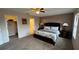 Well-lit main bedroom with a large bed, carpet, walk-in closet, and nightstands at 16631 Lazy Breeze Loop, Clermont, FL 34714