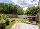 Lush backyard featuring a brick wall, garden bed, sandbox, and mature trees at 1672 Canoe Creek Rd, Oviedo, FL 32766