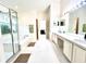 Bright bathroom featuring a glass shower, soaking tub, double vanity sinks and decorative lighting at 1672 Canoe Creek Rd, Oviedo, FL 32766