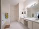 Bright bathroom boasts a large mirror, double sinks, tub, and tile floors at 1672 Canoe Creek Rd, Oviedo, FL 32766