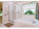 Bright bathroom featuring a tub, shower, and window with decorative vines at 1672 Canoe Creek Rd, Oviedo, FL 32766