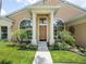 Charming home exterior with lush landscaping, a well-manicured lawn, and an inviting front entrance at 1672 Canoe Creek Rd, Oviedo, FL 32766