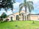 Charming single-story home featuring a stucco facade, manicured lawn, and a mature palm tree at 1672 Canoe Creek Rd, Oviedo, FL 32766