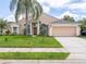 Charming single-story home with a well-maintained lawn, mature landscaping, and a two-car garage at 1672 Canoe Creek Rd, Oviedo, FL 32766