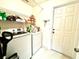 Functional laundry room with a washing machine, dryer, shelving, and convenient access to the exterior at 1672 Canoe Creek Rd, Oviedo, FL 32766