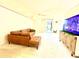 Bright living room with a comfortable sectional couch, entertainment center, and sliding glass doors to patio at 1672 Canoe Creek Rd, Oviedo, FL 32766