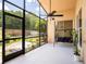 Inviting screened patio with ceiling fan, swing, and view of the lush, green backyard at 1672 Canoe Creek Rd, Oviedo, FL 32766