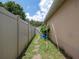 Exterior side yard view showing a walkway leading to a gate and greenery along the fence at 1672 Canoe Creek Rd, Oviedo, FL 32766
