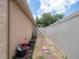 Exterior side yard view showing a walkway leading to a gate and landscaping features at 1672 Canoe Creek Rd, Oviedo, FL 32766