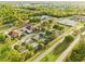 Overhead view of community center and tennis courts surrounded by lush green landscape, parking areas and a public road at 178 Marion Oaks Ln, Ocala, FL 34473