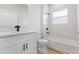 Modern bathroom features white marble tile, dark hardware, and a vanity with quartz countertop at 178 Marion Oaks Ln, Ocala, FL 34473