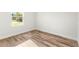Bright bedroom boasts hardwood flooring and neutral walls illuminated by natural light from a window at 178 Marion Oaks Ln, Ocala, FL 34473
