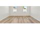 Bright room with hardwood flooring illuminated by natural light from two windows at 178 Marion Oaks Ln, Ocala, FL 34473