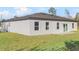 Back exterior view of home with green grass, sliding glass doors and neutral colored stucco at 178 Marion Oaks Ln, Ocala, FL 34473