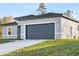 Exterior view of a modern gray home featuring a spacious driveway and attached garage at 178 Marion Oaks Ln, Ocala, FL 34473
