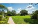 A large backyard with a brick pathway, large trees, and a clear blue sky at 19951 Quinlan St, Orlando, FL 32833
