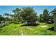 Spacious backyard with grassy lawn and mature trees, featuring a shed for extra storage or hobbies at 19951 Quinlan St, Orlando, FL 32833