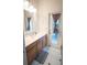 Well-lit bathroom featuring a vanity with modern fixtures, a walk-out door, and tiled floors for a clean and inviting space at 19951 Quinlan St, Orlando, FL 32833