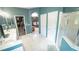 A bathroom with tiled floors, double sinks, shower, and a view of the bedroom and walk-in closet at 19951 Quinlan St, Orlando, FL 32833
