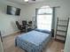 Bedroom with a large window, desk, TV, and sleek hardwood floors perfect for a modern and comfortable lifestyle at 19951 Quinlan St, Orlando, FL 32833