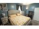 Cozy blue bedroom with a queen-sized bed, soft lighting, and a decorative dresser, offers a relaxing personal space at 19951 Quinlan St, Orlando, FL 32833
